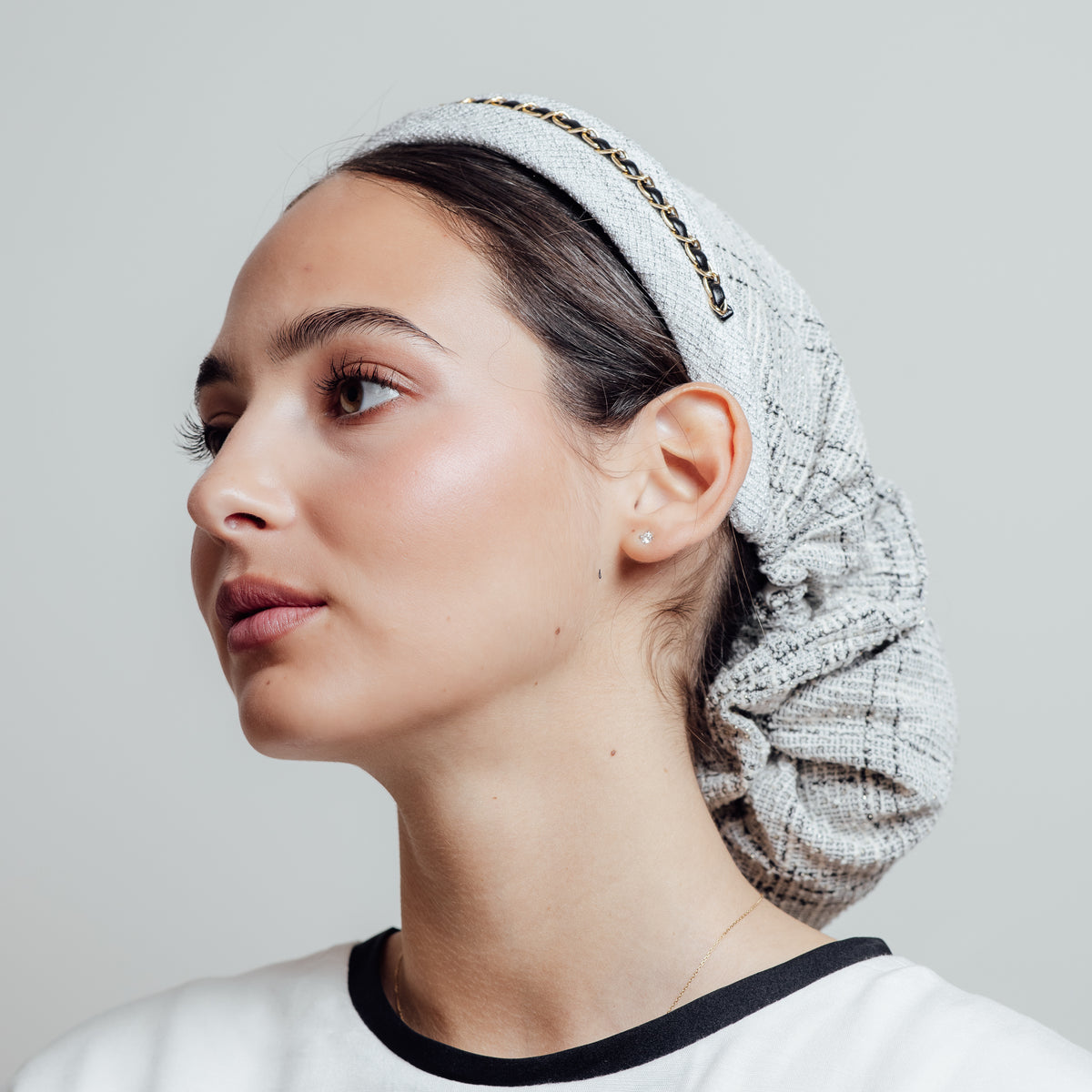 Gabrielle White, chaîne dorée et tweed léger