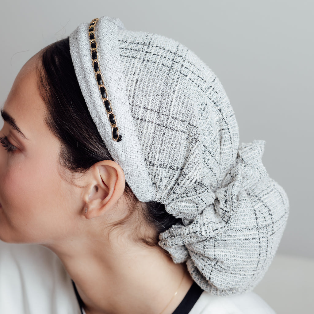 Gabrielle White — vue arrière, le tweed clair enveloppant la chevelure
